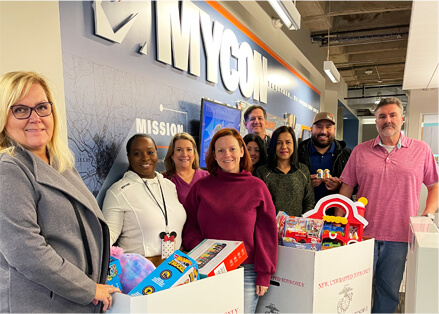 A group of people standing in front of boxes of toys.