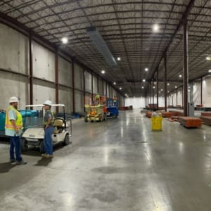 Two men standing in a warehouse with carts.