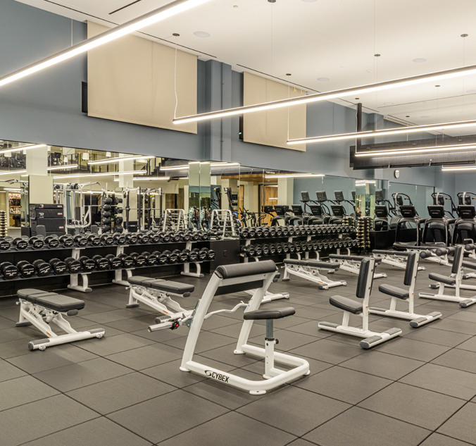 A gym with a lot of equipment and mirrors.