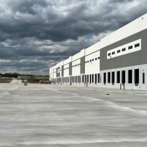 A large warehouse with a cloudy sky.