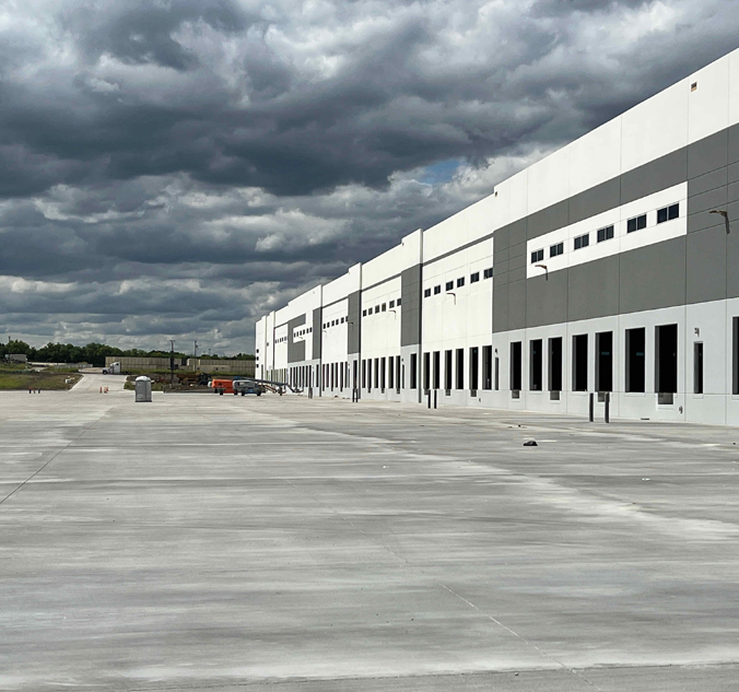 A large warehouse with a cloudy sky.