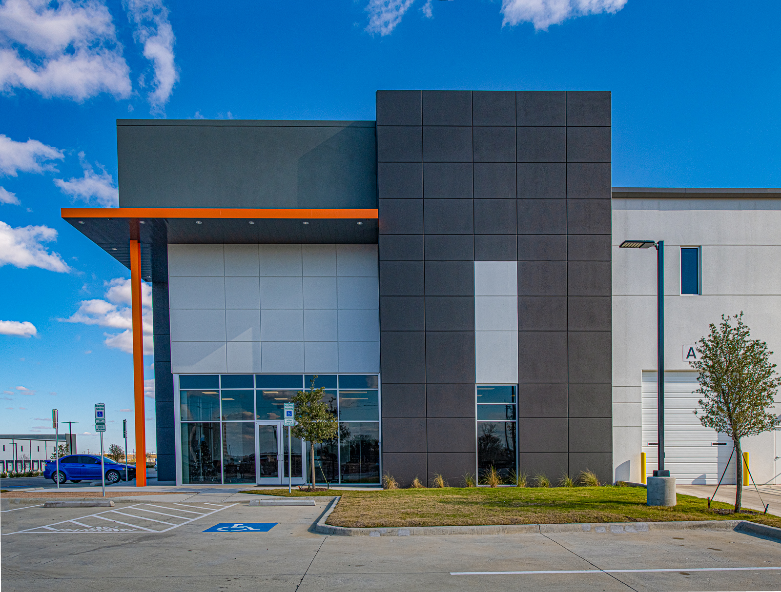 An orange and black building with a parking lot.