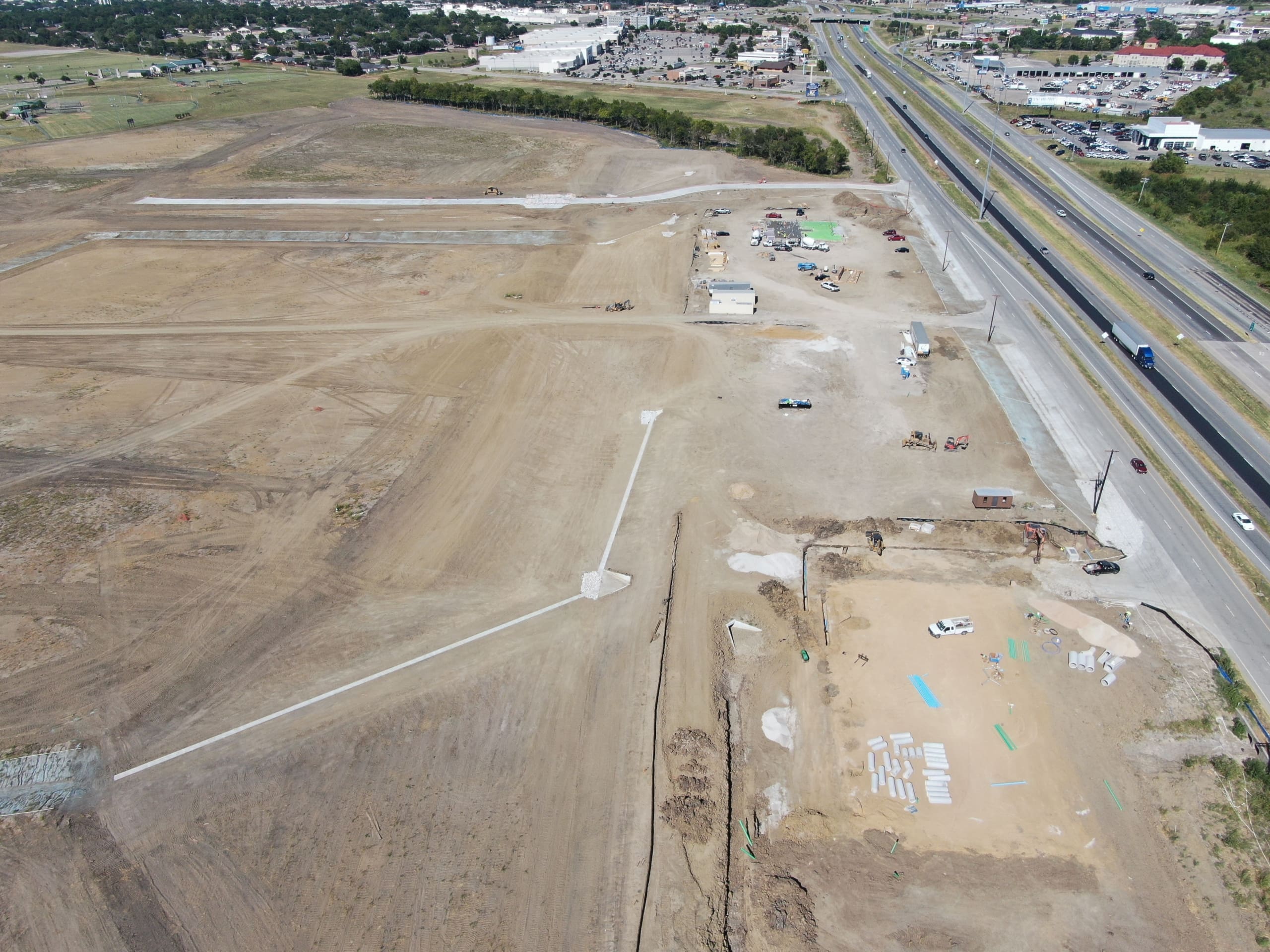 An aerial view of a construction site near a highway.