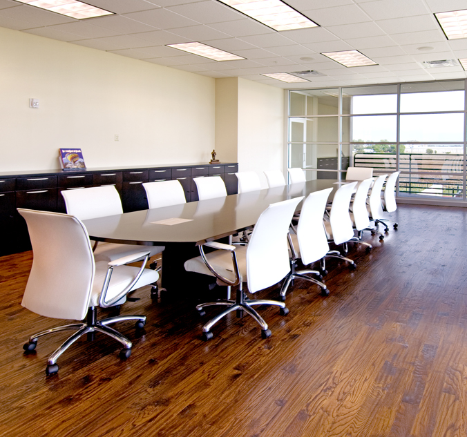 A conference room with a large table and chairs.
