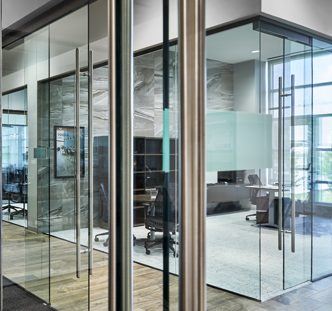 A glass door in an office with a glass wall.