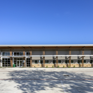 The exterior of a school building with a blue sky.