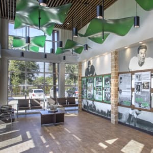 A lobby with green ceiling fans and pictures on the wall.