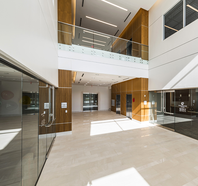 The lobby of a modern office building with glass walls.