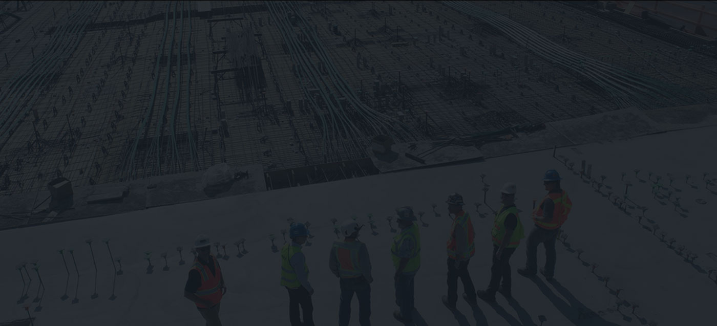 A group of construction workers standing on a construction site.