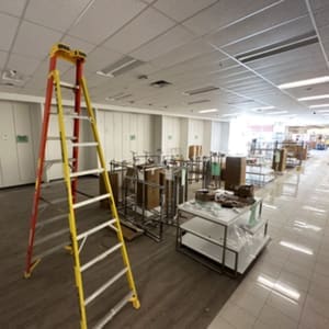 A large room with boxes and a ladder.