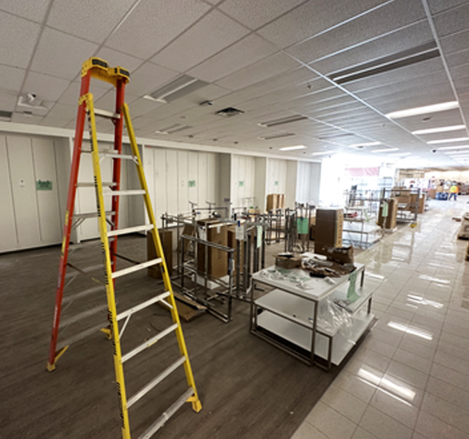 A large room with boxes and a ladder.