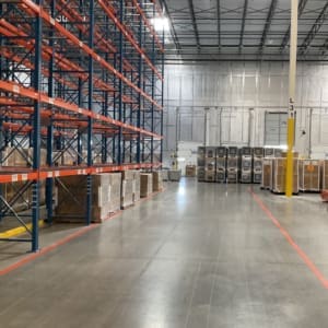 A warehouse with a lot of pallets and boxes.