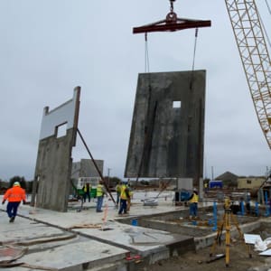 A crane is lifting a large piece of concrete.