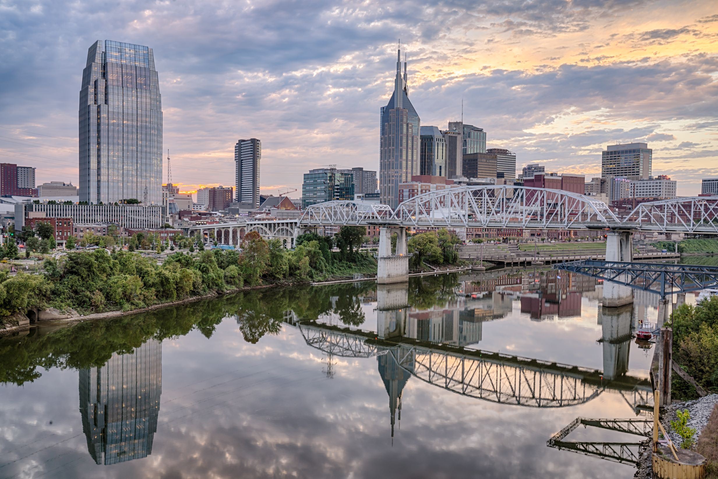 Downtown nashville, tennessee skyline at dusk with reflection on the cumberland river.