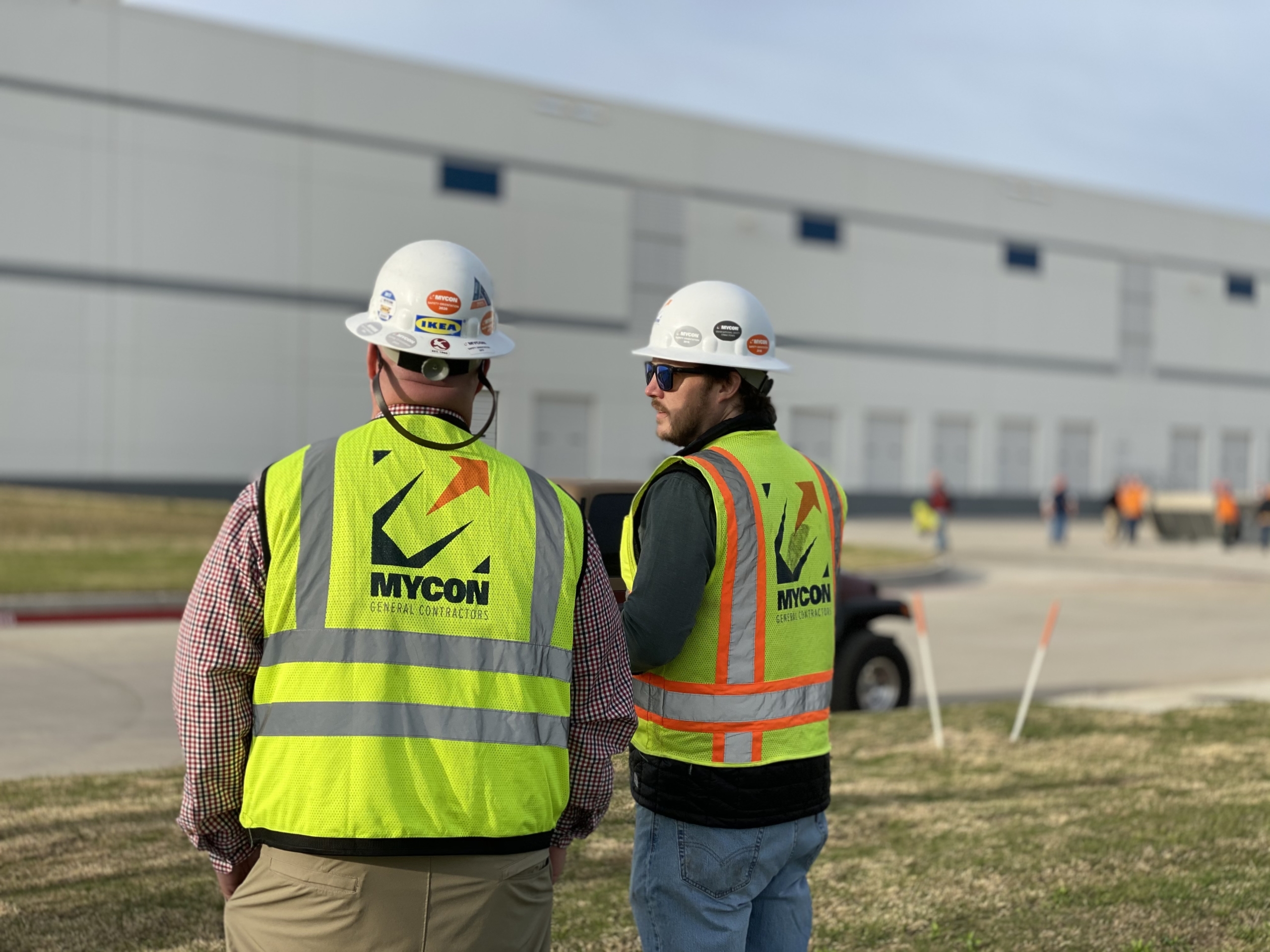 Two construction workers standing in front of a building.