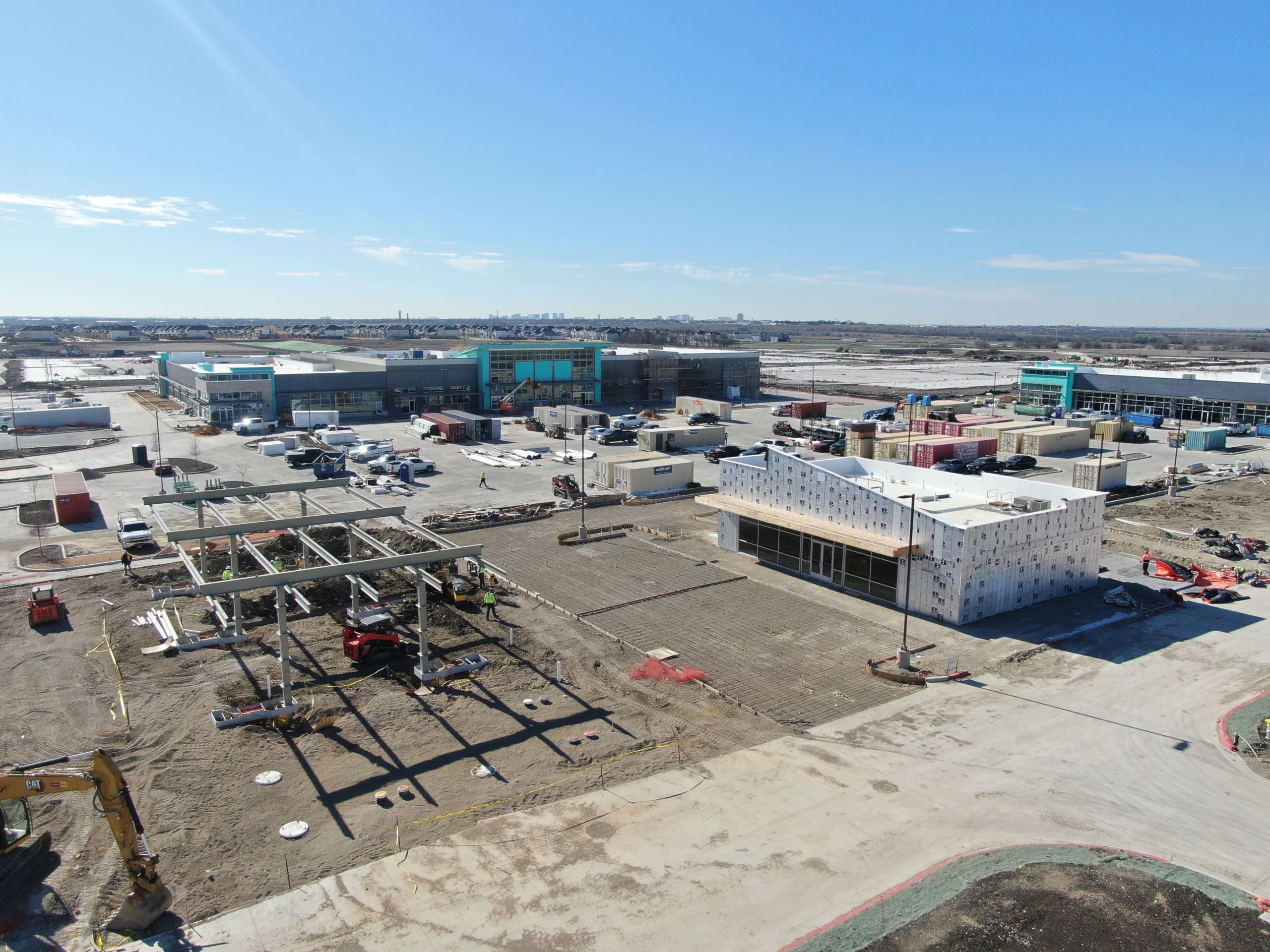 Aerial view of an industrial construction site with buildings under development and construction vehicles.