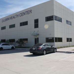 A two-story white building labeled "Lumin Health Center," located near Star Medical Center, with cars parked in front on a sunny day.