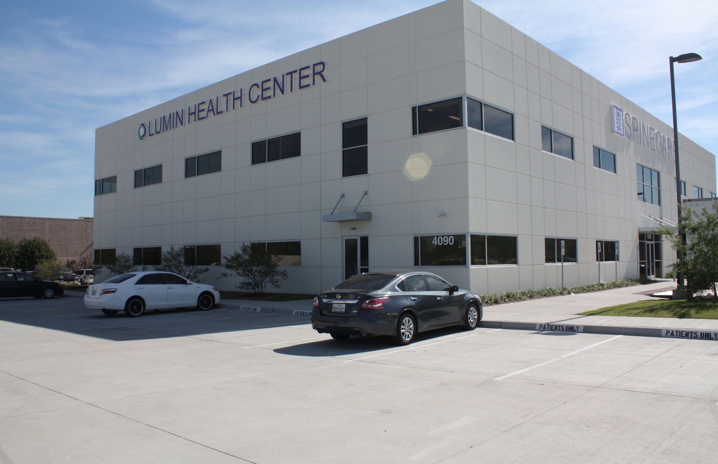 A two-story white building labeled "Lumin Health Center," located near Star Medical Center, with cars parked in front on a sunny day.