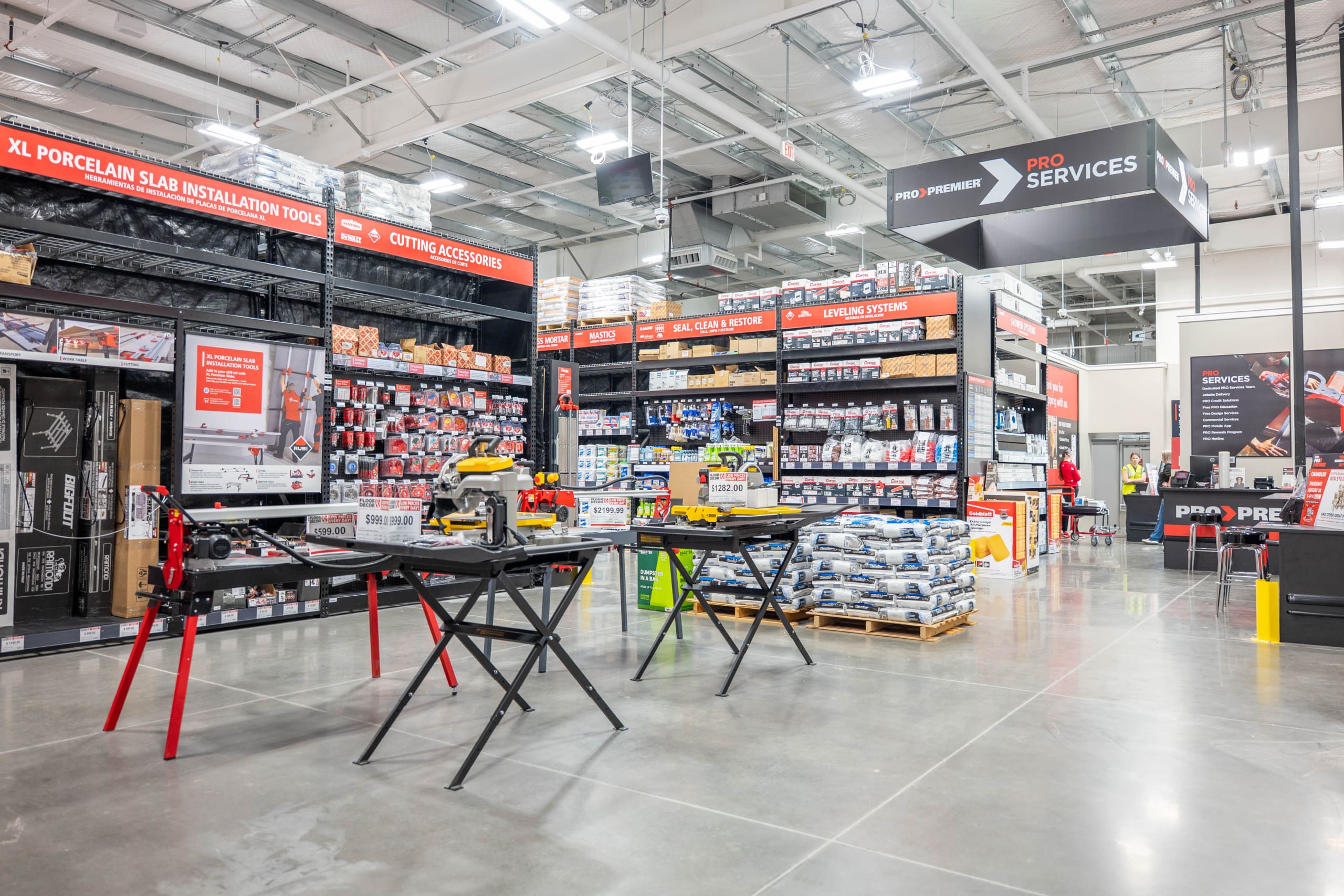 A hardware store interior with tools, building materials, and supplies organized on shelves; saws and equipment displayed on tables in the foreground, perfect for any construction project.
