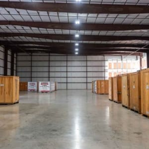 Large indoor storage facility at U-Haul of McKinney with wooden crates and U-Haul U-Box containers arranged along the walls on a polished concrete floor. U-Haul, Self Storage, Warehouse, Storage Building